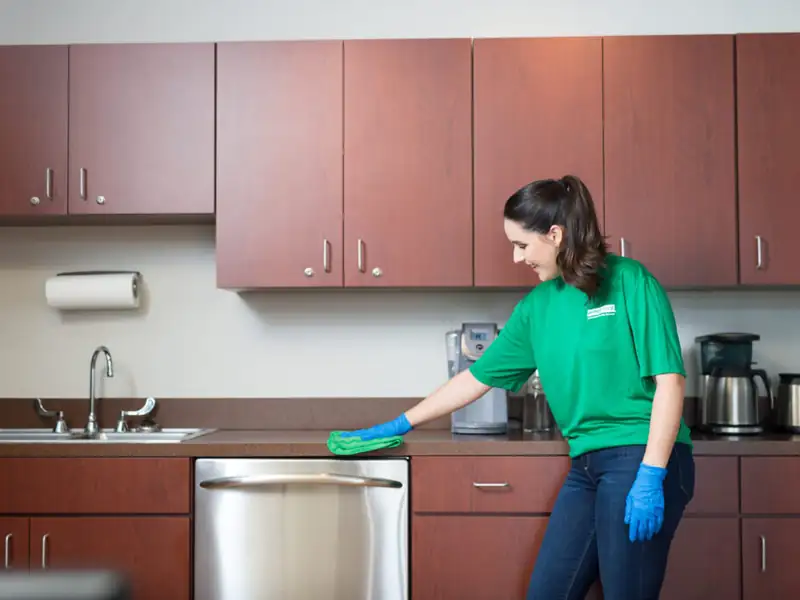Office Pride employee cleaning a break room