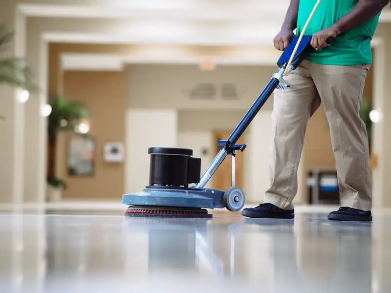 Office Pride employee operating a floor buffer